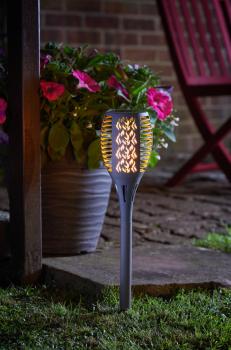 Preview: Weg-Solarlampe in Form einer Fackel. Beleuchtet bei Nacht im Garten.